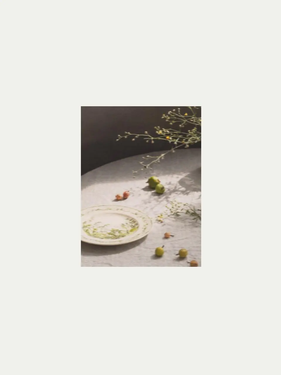 Botanical ceramic plate with lily of the valley pattern placed on a linen tablecloth, styled as elegant crockery tableware and a natural decoration for the table.